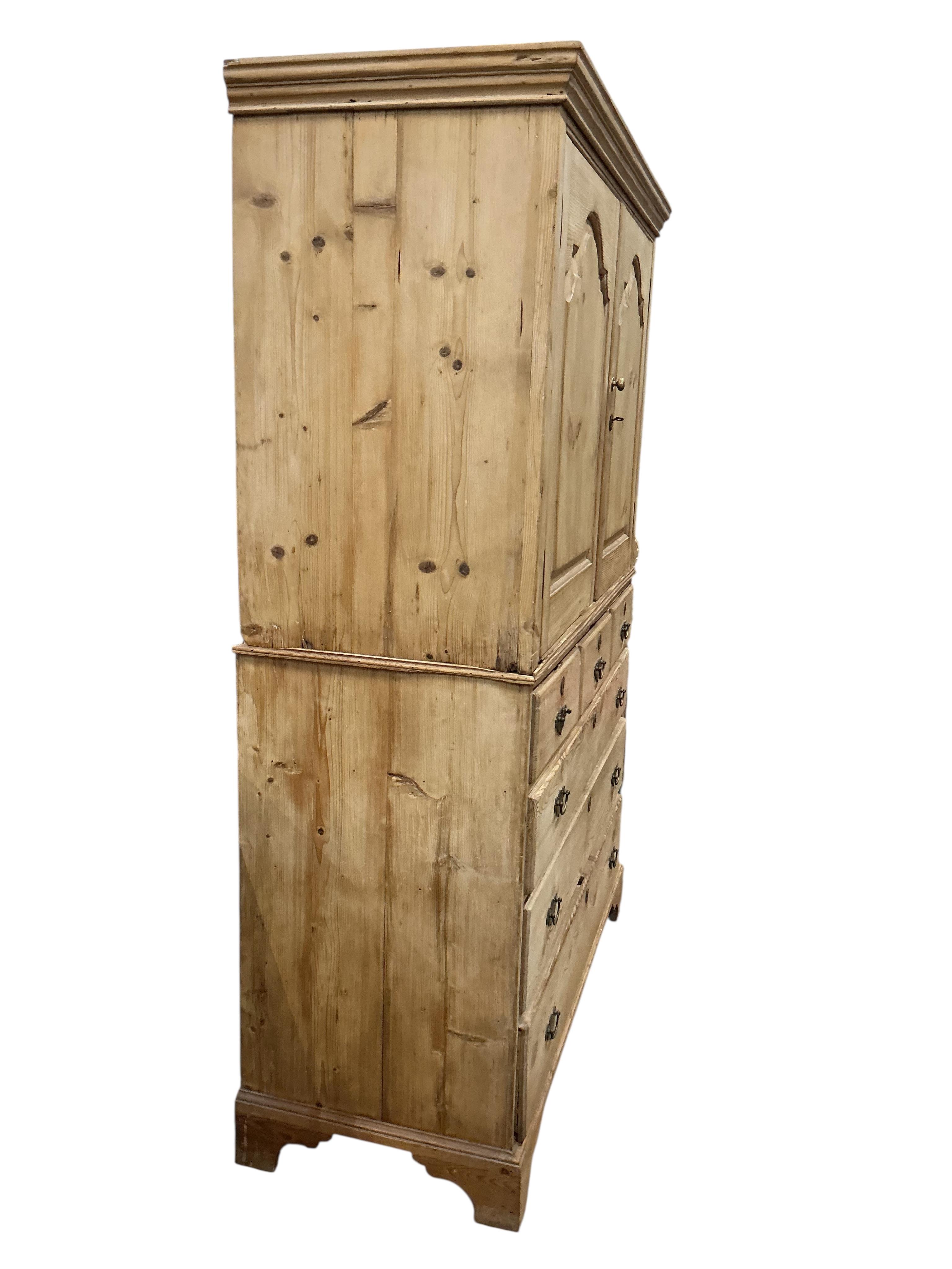 An early 19th century pine two part press cupboard, width 125cm, depth 54cm, height 191cm